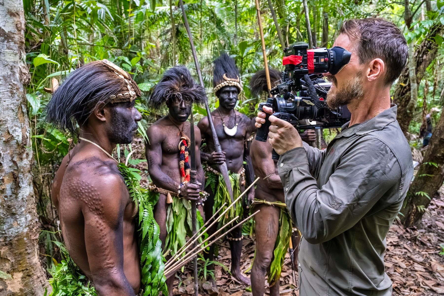 Camera operator filming warriors in the rainforest