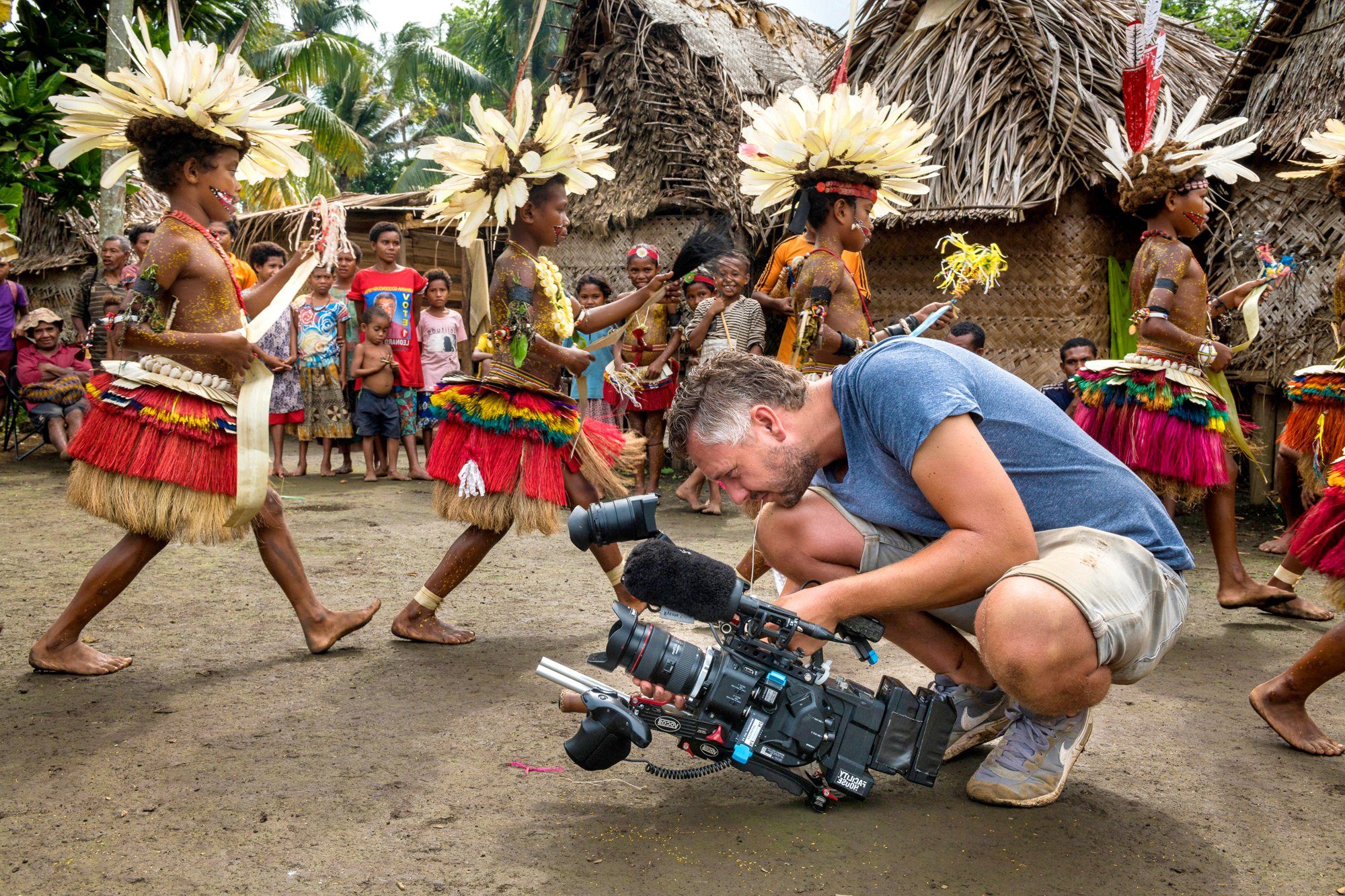 Cameraman filming traditional dancers in the Trobriand Islands