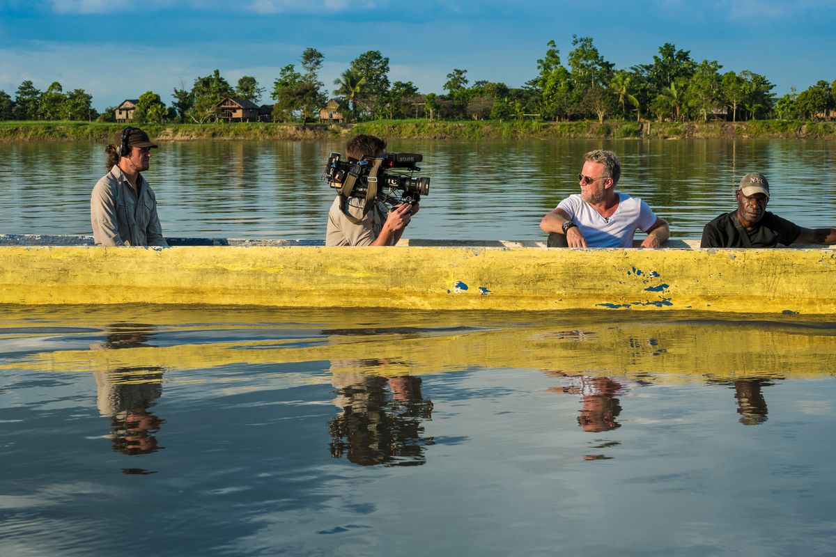 Camera and sound crew filming in a dugout canoe on the Sepik