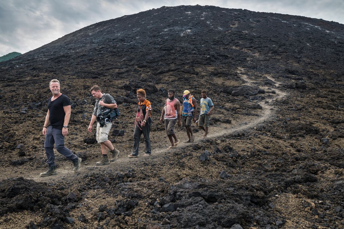 Crew and guides walking across the lava field of Tavurvur volcano