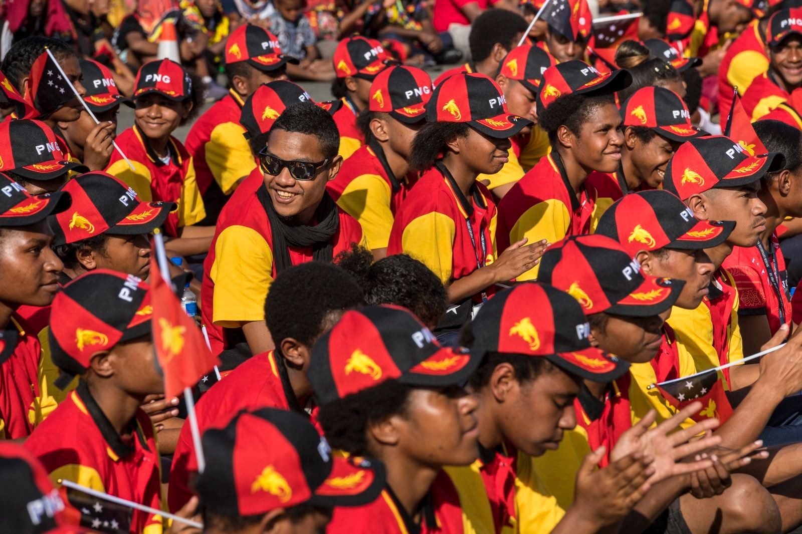 Crowd in red and yellow caps celebrating Independence Day