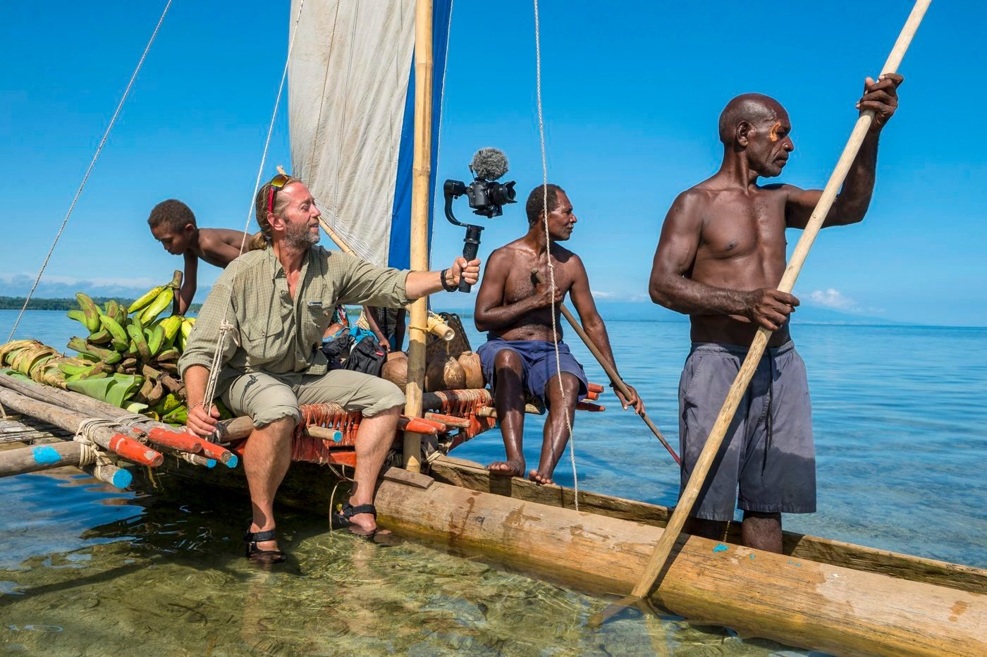 Film crew recording on a traditional sailing canoe in Papua New Guinea