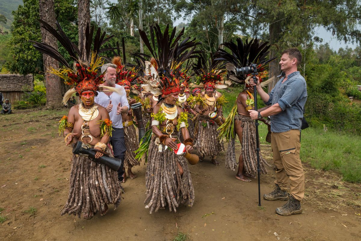 Presenter dancing with Highlands women while a camera operator films on a monopod