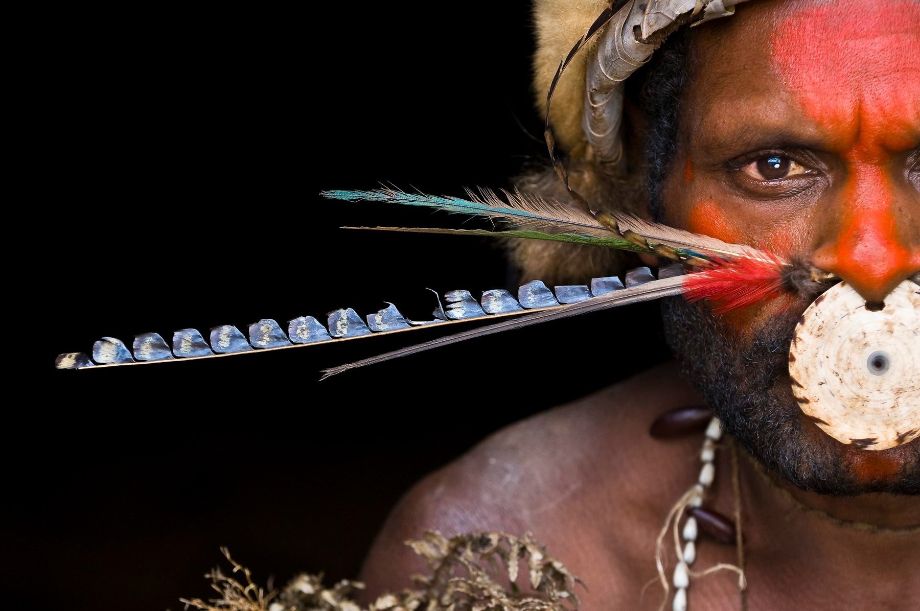 Portrait of a man with painted face and shell nose ornament