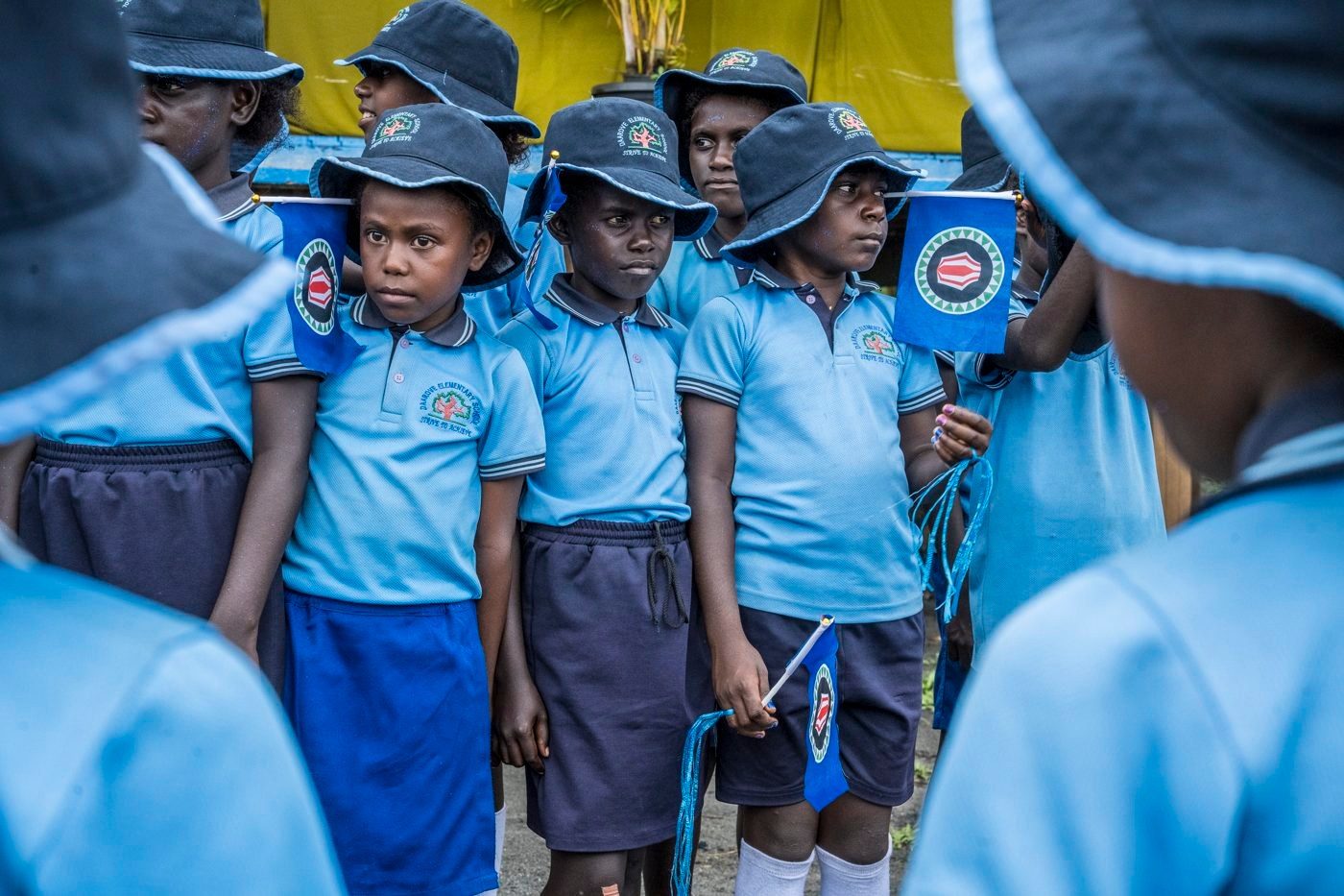 Schoolchildren holding Bougainville flags at a ceremony