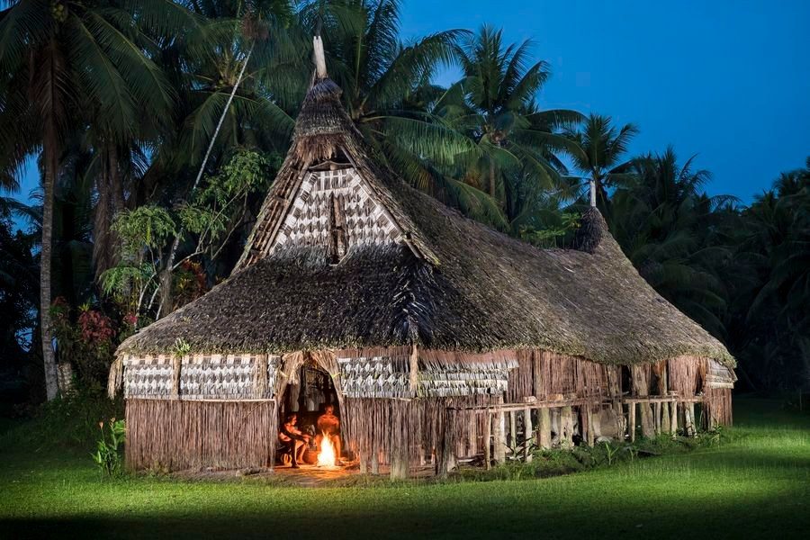 Spirit house lit by a fire at dusk